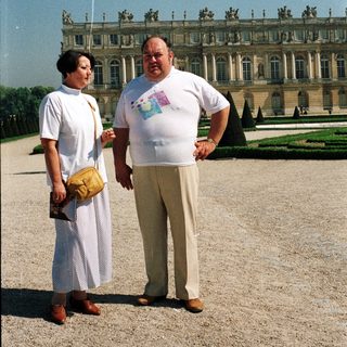 Couple poses in front of a large palace exterior.