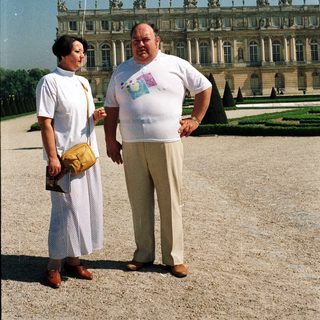 Couple poses in front of a large palace exterior.