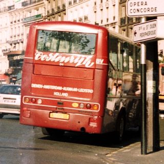 Parisian street scene with a red double-decker bus and statue.