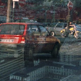 Parisian street scene with a red double-decker bus and statue.