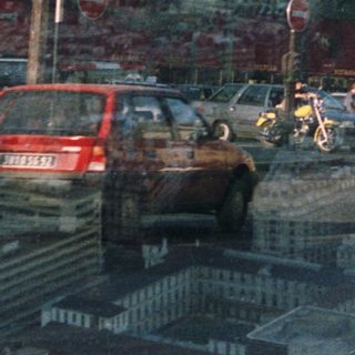 Parisian street scene with a red double-decker bus and statue.