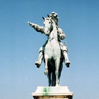 Statue of a rider on horseback in a palace square.