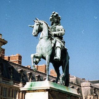 Monumental equestrian statue stands in front of a palace.