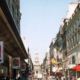 Busy street scene with buildings and people in Paris.