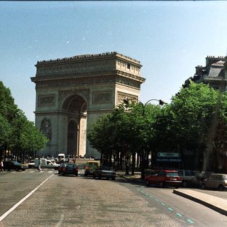 The Arc de Triomphe stands at the end of a Parisian avenue.