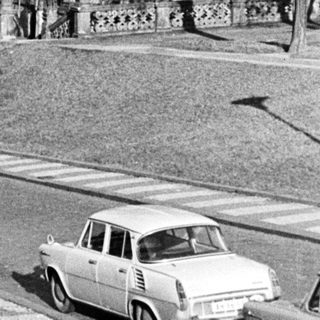 Black and white image of a baroque church and car.