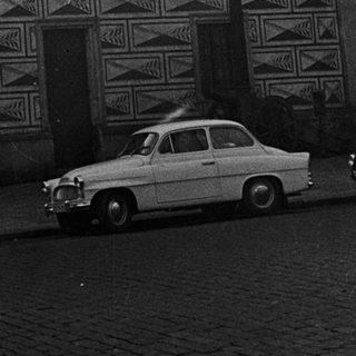 Black and white photo of an ornate building and cars.