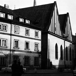 Black and white photo depicts old buildings and cars.