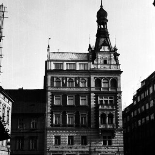 Black and white photo of an ornate building with cars.