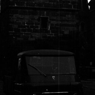 Black and white photo of a clock tower and buildings.