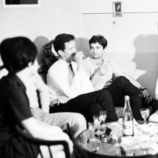 Group of people socializing in a room with drinks.