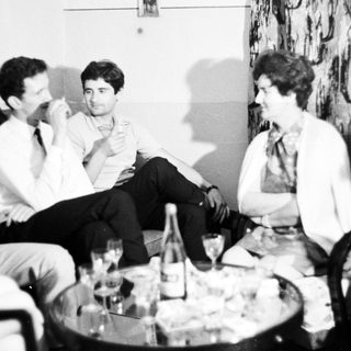 Group of people socializing in a room with drinks.