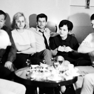 Group of people sitting, gathered around a table.
