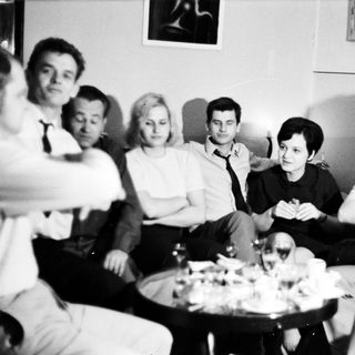 Group of people sitting, gathered around a table.