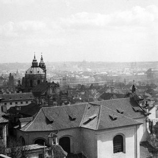Black and white cityscape with church spires and rooftops.