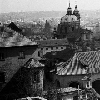 Black and white cityscape with church spires and rooftops.