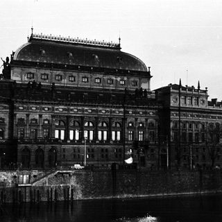 Grand building overlooking water, likely a historical public structure.