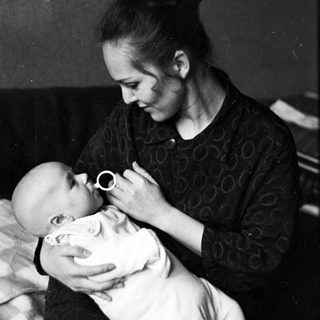 Woman gently cradling and comforting a baby.
