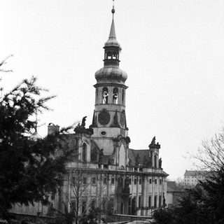 Black and white image of a grand building with a spire.