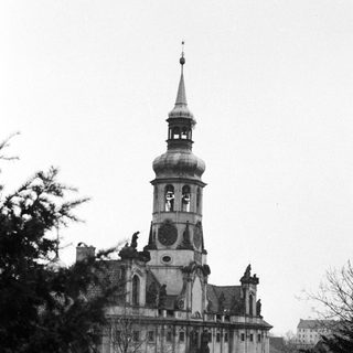 Black and white image of a grand building with a spire.