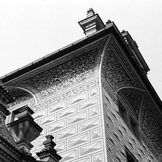 Ornate, black and white architecture with decorative details and chimney.