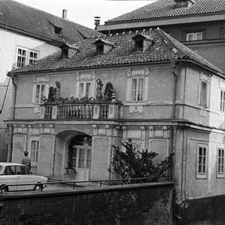 Black and white photo shows a building with a balcony.