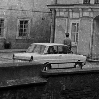Black and white photo shows a building with a balcony.