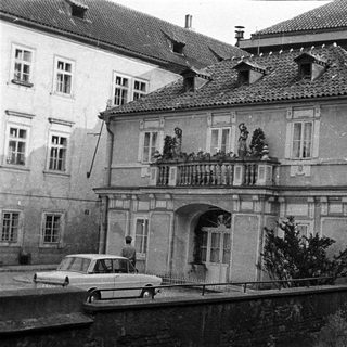 Black and white photo shows a building with a balcony.