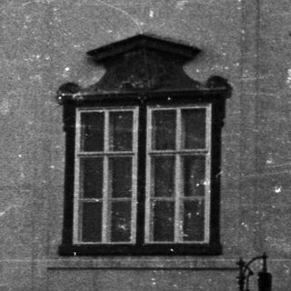 Black and white image of a building and a truck.