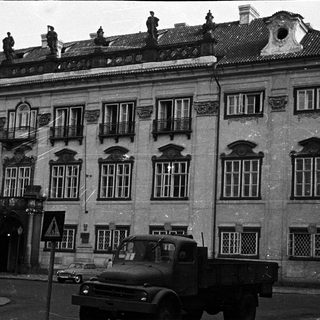 Black and white image of a building and a truck.