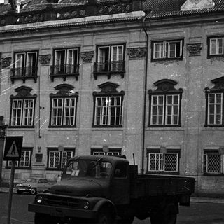 Black and white image of a building and a truck.