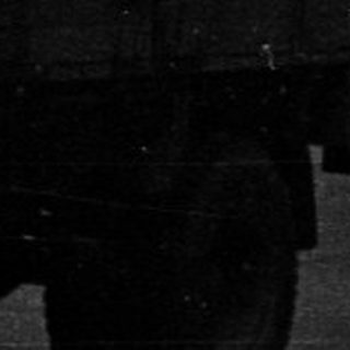Black and white image of a building and a truck.