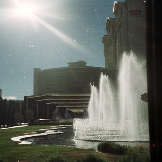 Fountain and Caesars Palace hotel visible under a bright sky.
