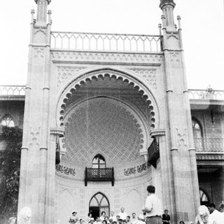 Group gathered in front of a large, ornate archway.