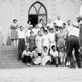 Group gathered in front of a large, ornate archway.