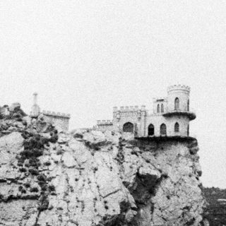 Castle dramatically perched atop a rocky cliffside.