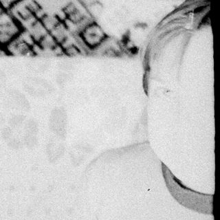Black and white photo of a baby lying in a bed.