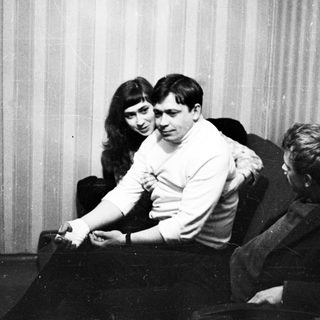 Three people sitting in chairs, appearing to be in a room.