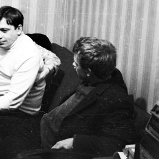 Three people sitting in chairs, appearing to be in a room.