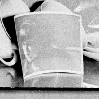 Vintage china displayed on shelves in a cabinet.