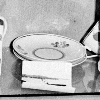 Vintage china displayed on shelves in a cabinet.
