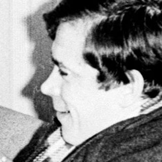 Couple seated on a couch, appearing to converse.