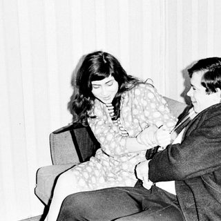 Couple seated on a couch, appearing to converse.