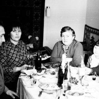 Family gathered around a table, seemingly sharing a meal.