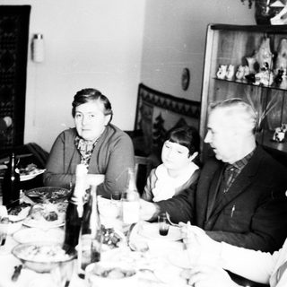 Family gathered around a table, seemingly sharing a meal.
