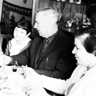 Family gathered around a table, seemingly sharing a meal.