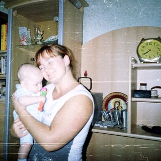 Woman holding a baby in a home setting.