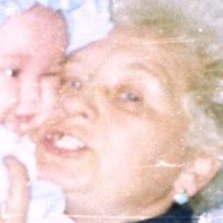 Woman holding a baby in front of a window.
