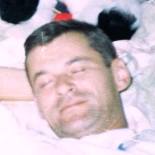 Men and baby sleep under large stuffed animals.