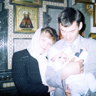 Couple holds baby in a church setting.